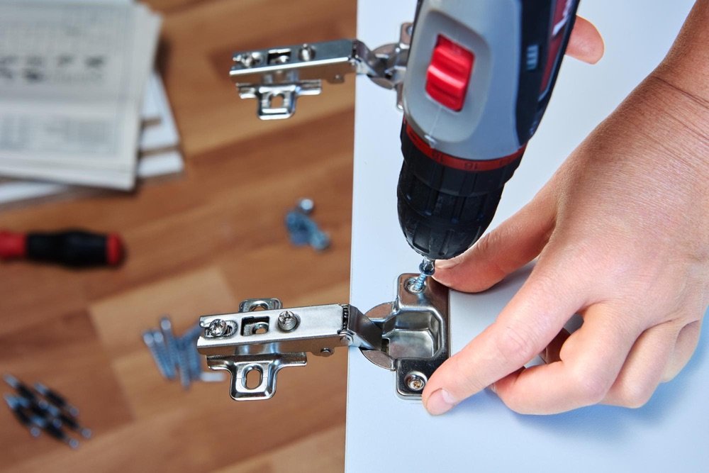 Handyman assembling furniture with power tools